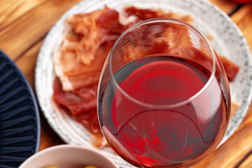 Meat slicing and wine on gray background