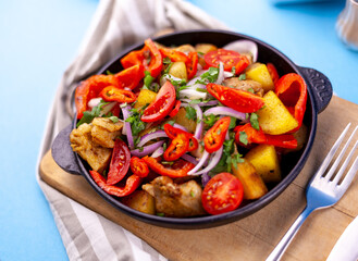 Pork ojakhuri with vegetables. Meat, potatoes, onions, herbs, peppers cooked and served in a skillet. A dish of Georgian cuisine. Meat food, lunch, dinner on the table.