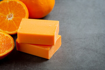 Orange soap with fresh orange on dark background