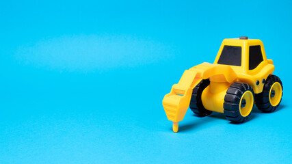 Toy tractor drill on a blue background with a place for text, a banner for a children's toy store