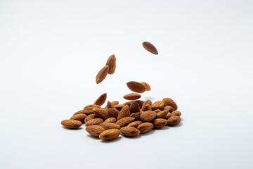 Almonds on a white background. Isolated almonds. Roasted almonds fall on a white surface