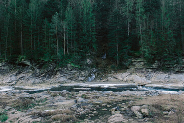 Winter mountain stream among rocks and stones