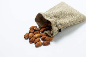 Almonds on a white background. Isolated almonds. Roasted almonds spilled out of the bag