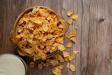 Cereal in bowl and milk on dark wooden background