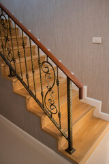 Staircase, wooden floor and black iron rail.