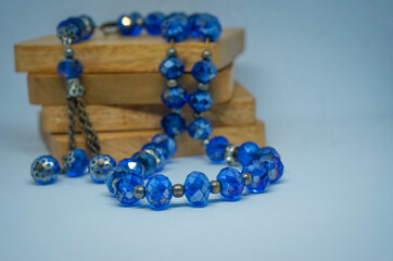 Rosary beads on wooden stack isolated white background, selective focus
