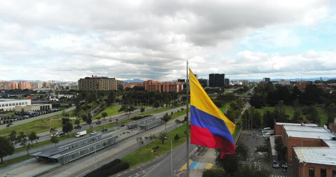 Aerial view of giant Colombian flag in Bogota, Colombia, panoramic lowering shot