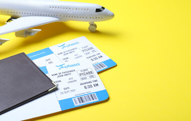 Passport with tickets and toy airplane on yellow background, space for text. Travel agency concept