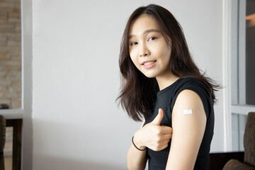 Healthy asian woman getting vaccinated immunity giving thumb up to vaccine program, concept of recommended inoculation, vaccination, vaccine volunteer or vaccinated patient