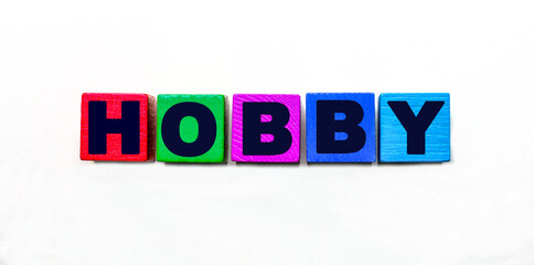 The word HOBBY is written on colorful cubes on a light background