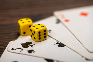 Playing cards and dice on a wooden table.