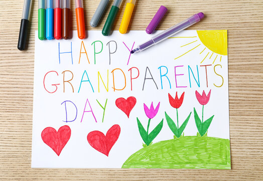 Beautiful drawing on wooden table, flat lay. Happy Grandparents Day