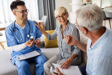 Obraz premium Male nurse talking to seniors patients while being in a home visit.