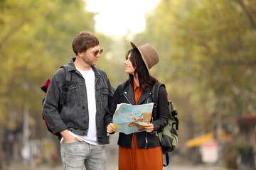 Couple of travelers with map on city street