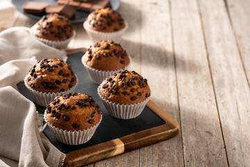 Just baked chocolate muffins on rustic wooden table. Copy space