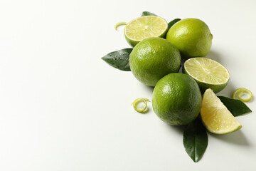 Ripe lime, leaves and peel on white background