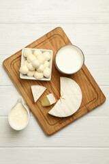 Fototapeta na wymiar Board with different dairy products on wooden background