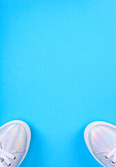 Silver sneakers on a blue background with place for text