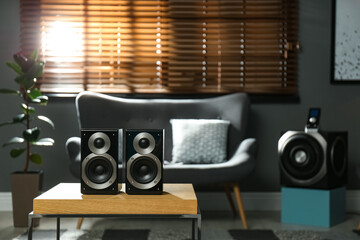 Modern audio speaker system on wooden table in living room. Interior design - obrazy, fototapety, plakaty