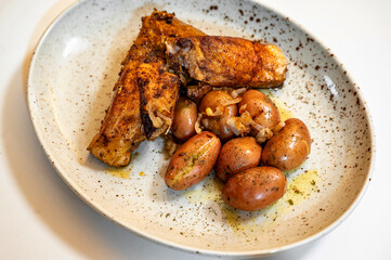 Roasted fish carp steak with boiled spring potato on plate.