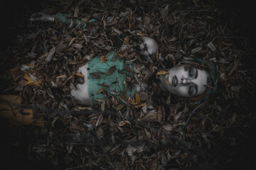 dead girl in autumn foliage wearing green and yellow robes