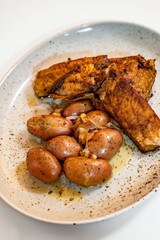 Fish carp steak with boiled spring potato on plate.