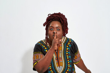 Portrait of plus size young woman showing silence gesture