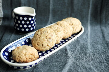 traditional oatmeal cookies on a bliue plate  and a jar of milk