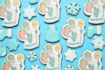 Tasty gingerbread cookies on light blue background, flat lay. St. Nicholas Day celebration