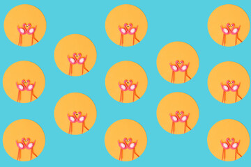 Pattern created of two flamingos toys in orange circle on neon blue background. Top view.