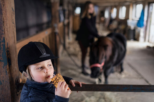 Girl drinking juice in stable
