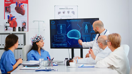 Group of specialist doctors analysing brain functions using high tech in medical boardroom, nurse testing new innovation. Medic studying diagnosis of patients working in hospital conference room