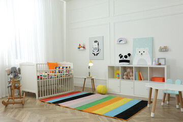 Cute baby room interior with stylish furniture and toys