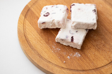 Sweets, marshmallows, lying on a wooden board, on the windowsill. Surprise, holiday of sweets, sugar addiction, handmade, the right sweets
