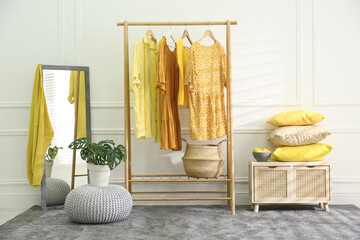 Stylish dressing room with clothes rack. Interior design in grey and yellow colors