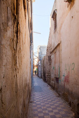 A man walking down an alley with mosaic floors in Ghadema, the old city, Tripoli, Libya.