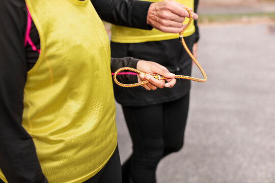 Visually impaired female triathlete running together with her guide