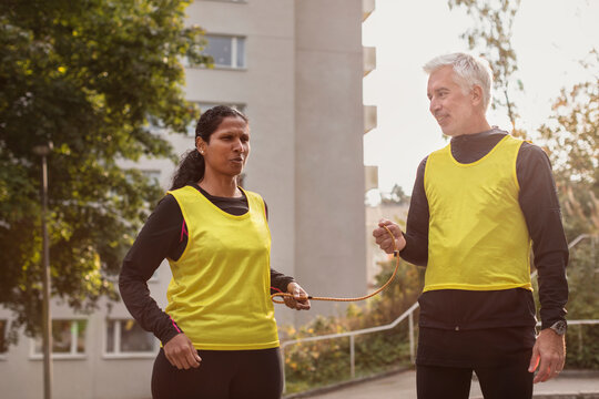 Visually impaired woman preparing for jogging with guide runner