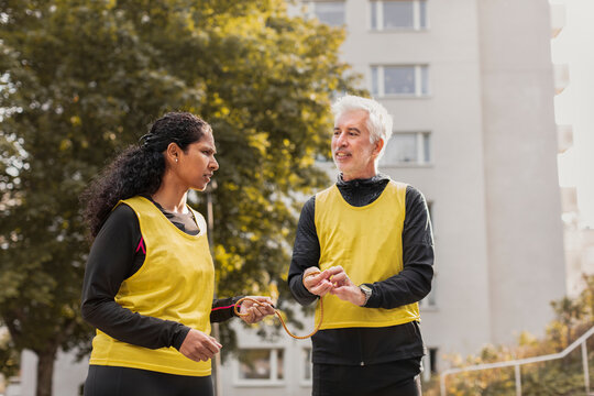 Visually impaired woman preparing for jogging with guide runner