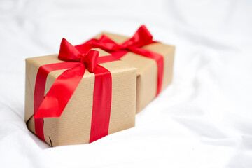 Red gift kraft box with ribbon. Valentine's Day gift in bed. Natural eco and bio gift. Sensual passion minimal gift in bed