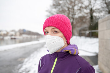 Young woman doing sport in winter outdoors in sportswear in ffp2 medical mask. Sport in Corona. Sportswoman. 