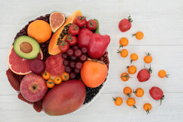 Fruit and vegetable collection high in lycopene and anthocyanins for a healthy heart with plant based food also high in antioxidants, dietary fibre, omega 3 and vitamins. Ethical eating concept.
