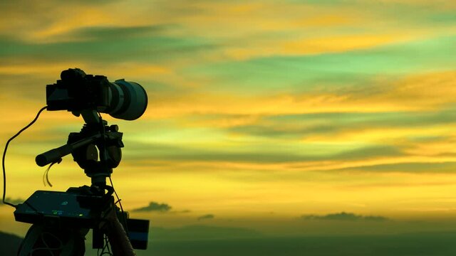 Professional camera on tripod taking picture film video of sunrise over sea water, Greece Peloponnese Mani Peninsula. Time lapse