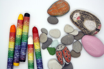 Fototapeta na wymiar Gray and white sea rocks and crayons on a white background.