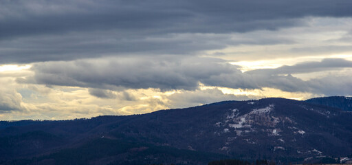 Naklejka na ściany i meble The Sun behind the clouds in winter in the mountains
