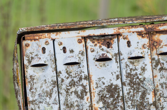 An old rusty post-box with a smiley face