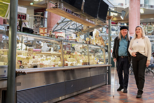 Senior couple at cheese stand in indoor market
