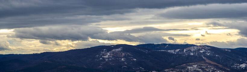 The Sun behind the clouds in winter in the mountains