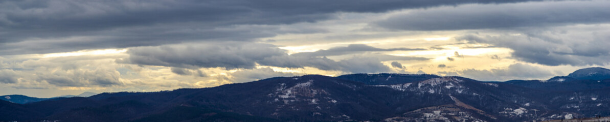 Fototapeta na wymiar The Sun behind the clouds in winter in the mountains