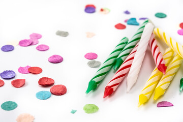 Colorful birthday candles and confetti isolated on white background. Copy space